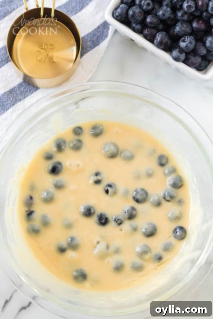 Folding fresh blueberries into the muffin batter