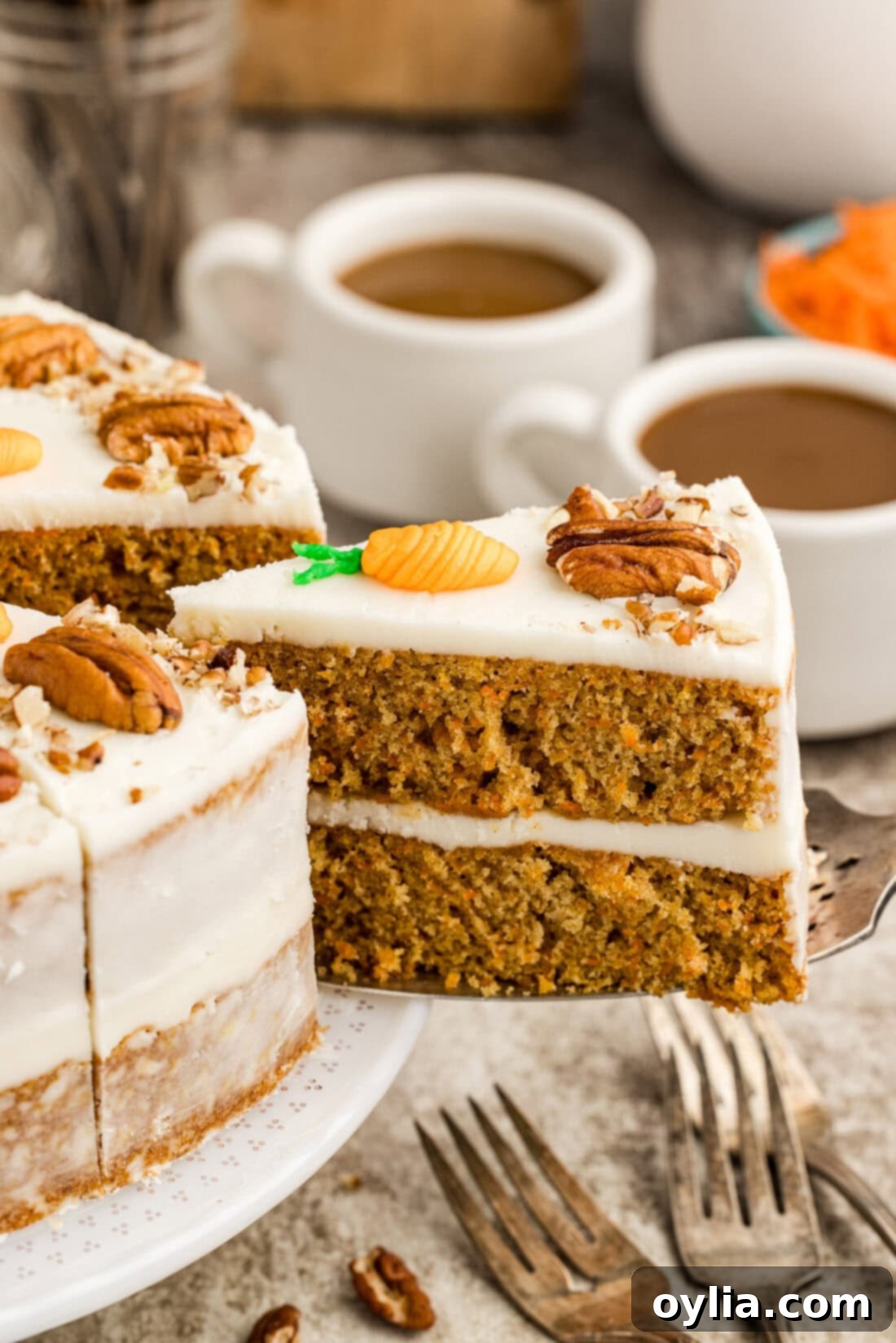 A slice of perfect carrot cake being removed from the two-tiered cake, showcasing its moist layers and creamy frosting.