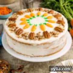 A beautifully decorated two-tiered carrot cake on a cake stand, ready to be served.