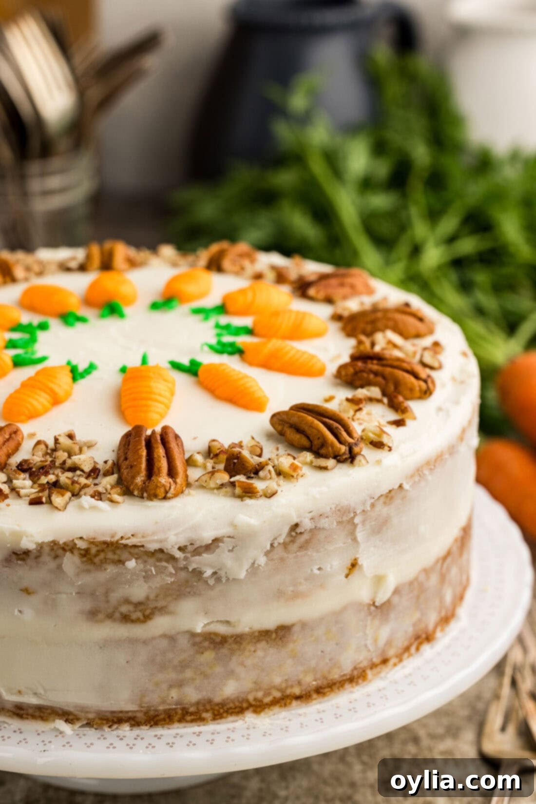 Close-up shot of a magnificent two-tiered carrot cake, beautifully frosted with cream cheese and decorated, sitting on a cake stand.