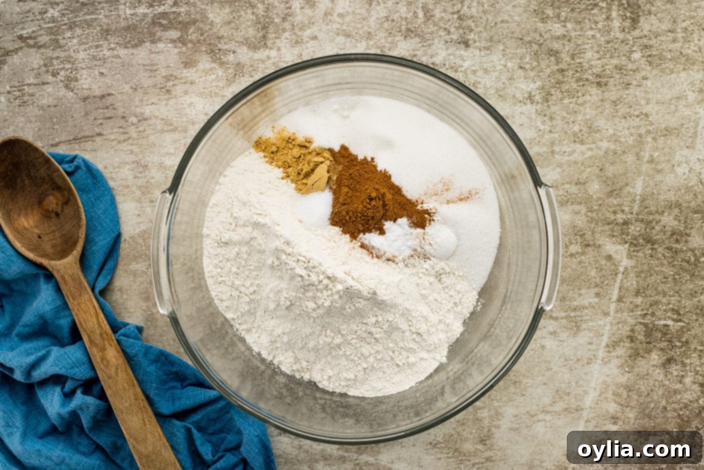 Dry ingredients for carrot cake, including flour, sugar, and spices, mixed in a large bowl.