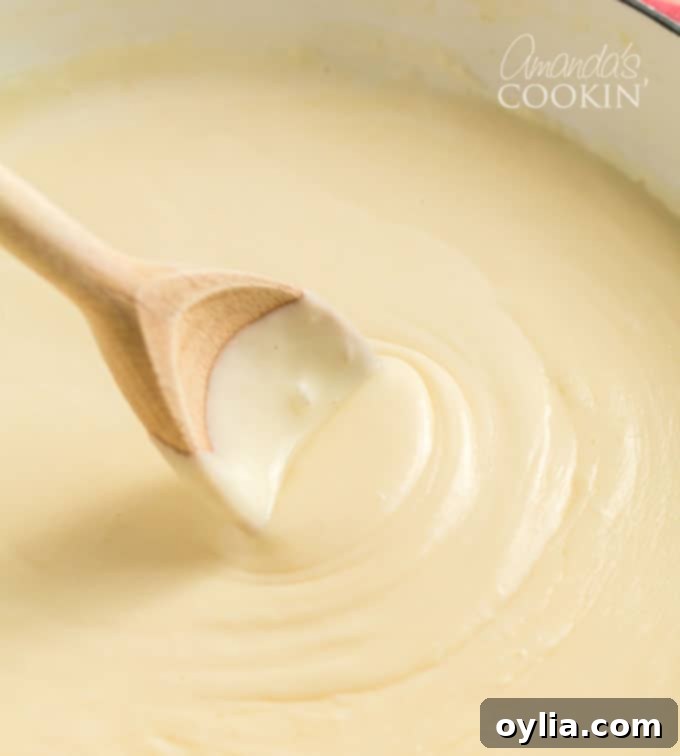 wooden spoon stirring cheese sauce
