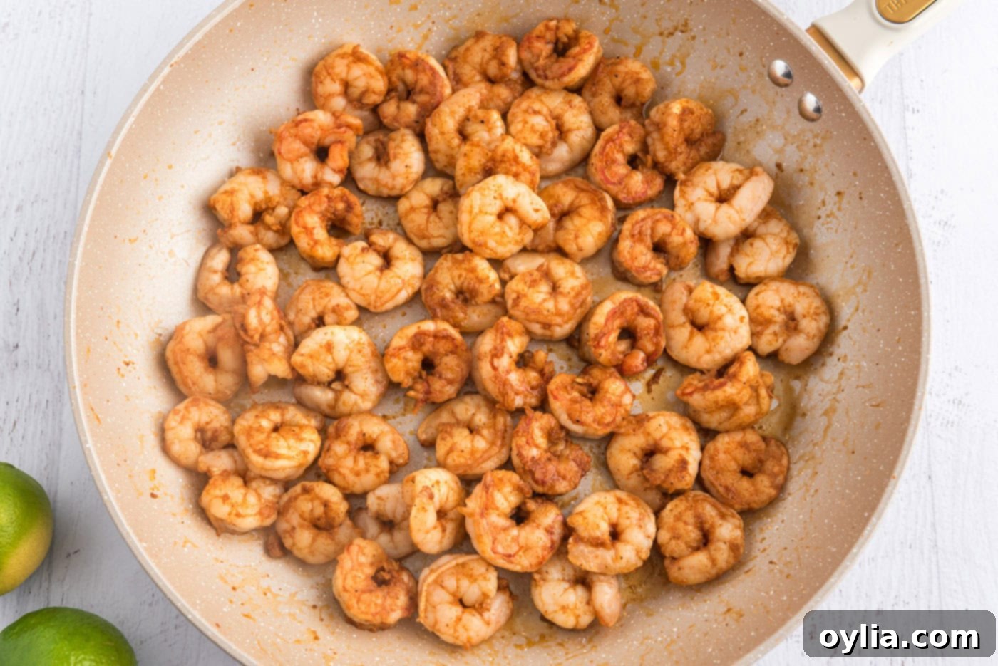 Cooked seasoned shrimp sizzling in a skillet, turning pink and opaque
