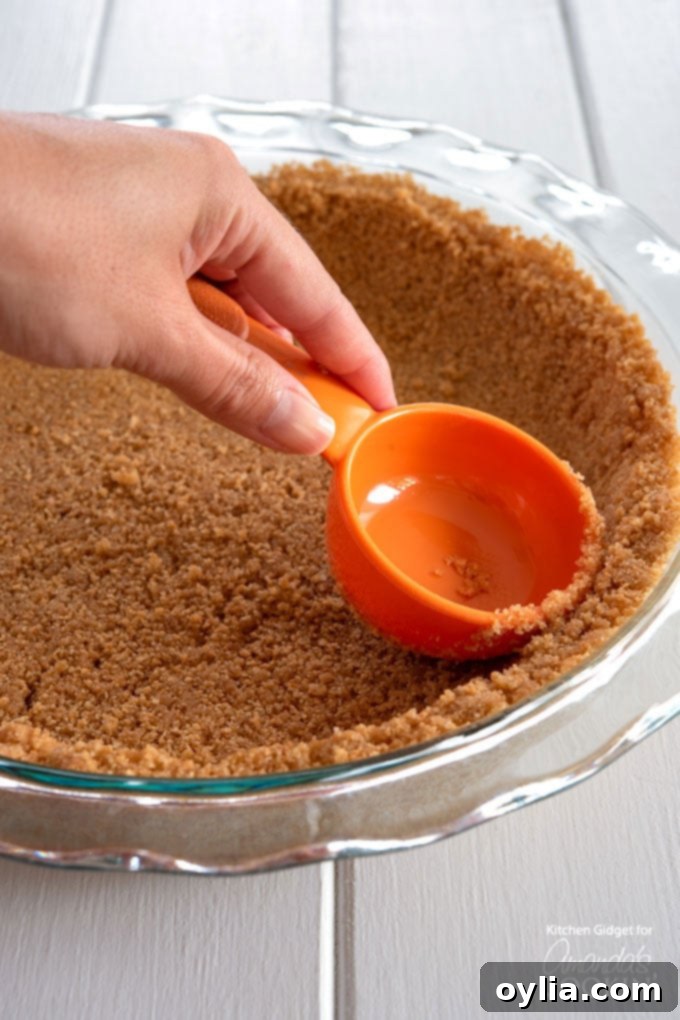 pressing down the graham cracker crust