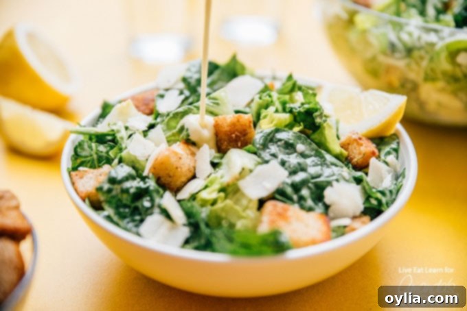dressing being added to a bowl of salad
