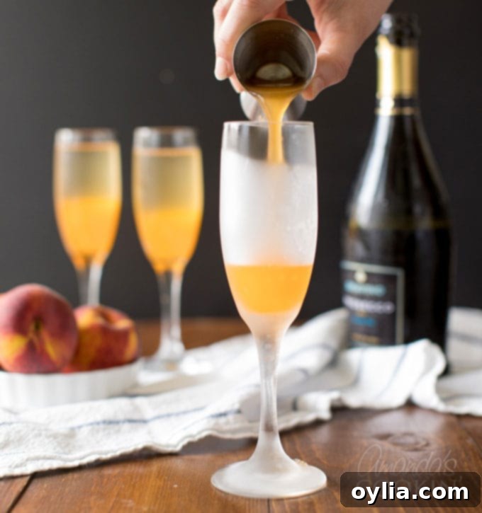 Carefully pouring measured peach puree into a chilled champagne flute for a Bellini.