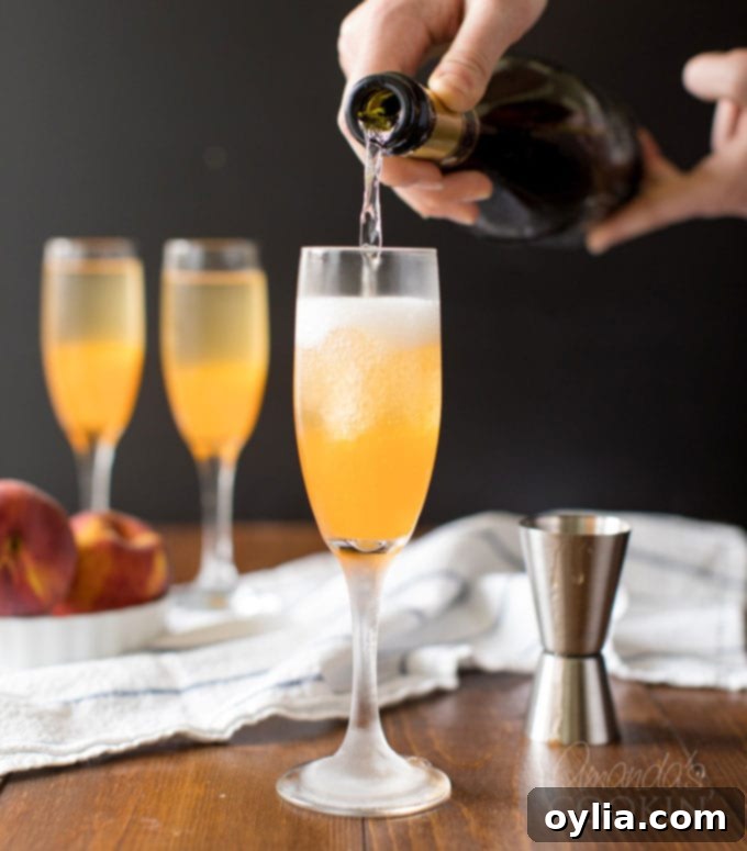 Slowly topping a champagne flute with Prosecco, creating effervescent bubbles over peach puree for a Bellini.
