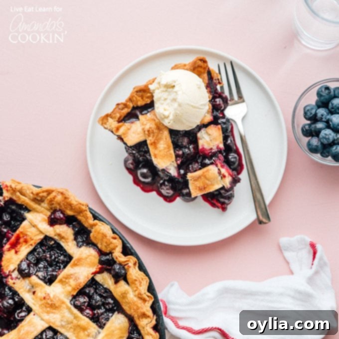 Blueberry Pie is a timeless classic. This recipe will show you how to make the perfect blueberry pie for your next party or get together. blueberry pie on plate with ice cream