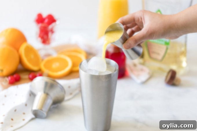 pouring orange juice into cocktail shaker with ice and tequila