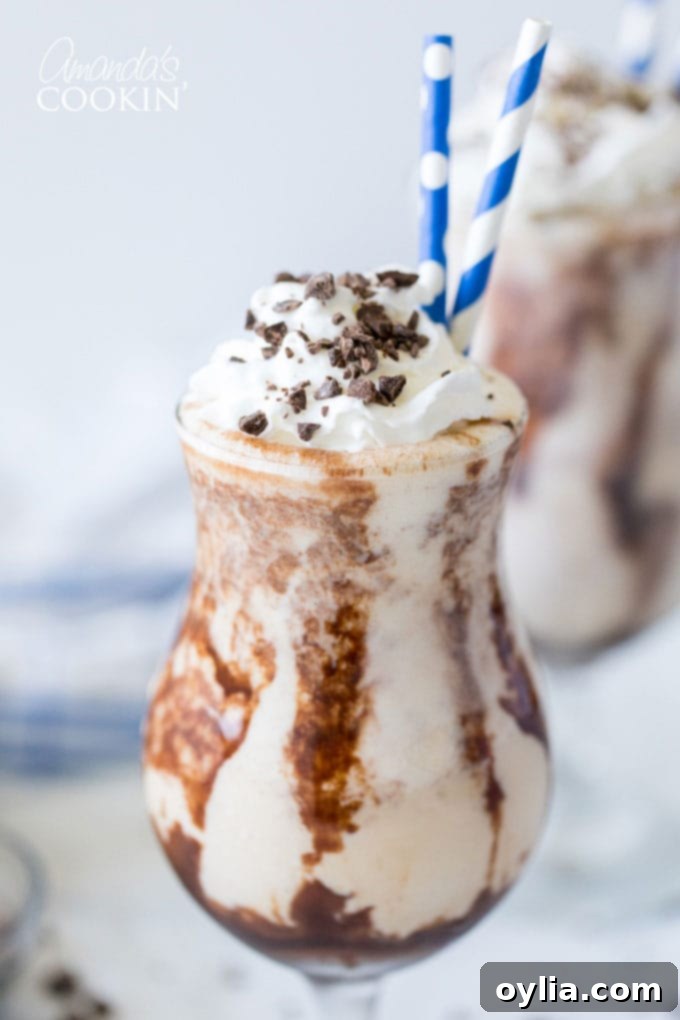 Close-up of a decadent Frozen Mudslide cocktail in a hurricane glass, garnished with chocolate shavings.