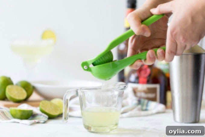 squeezing the juice of a lime into a glass