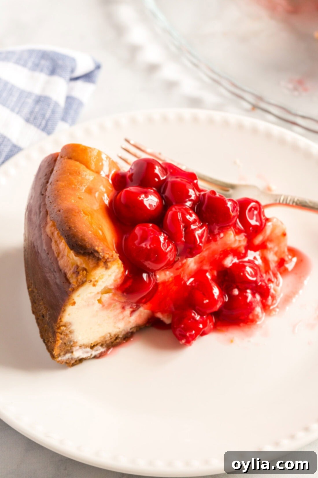 Slice of Cherry Cheesecake on a plate, perfectly showing the creamy texture and cherry topping.
