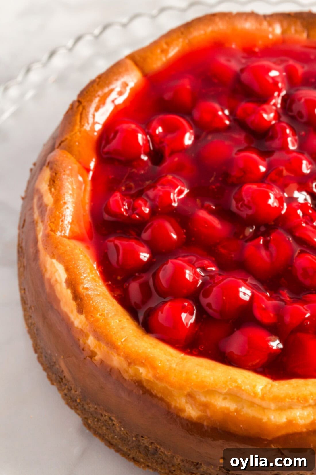 Close up photo of a Cherry Cheesecake with a rich, glossy cherry topping.