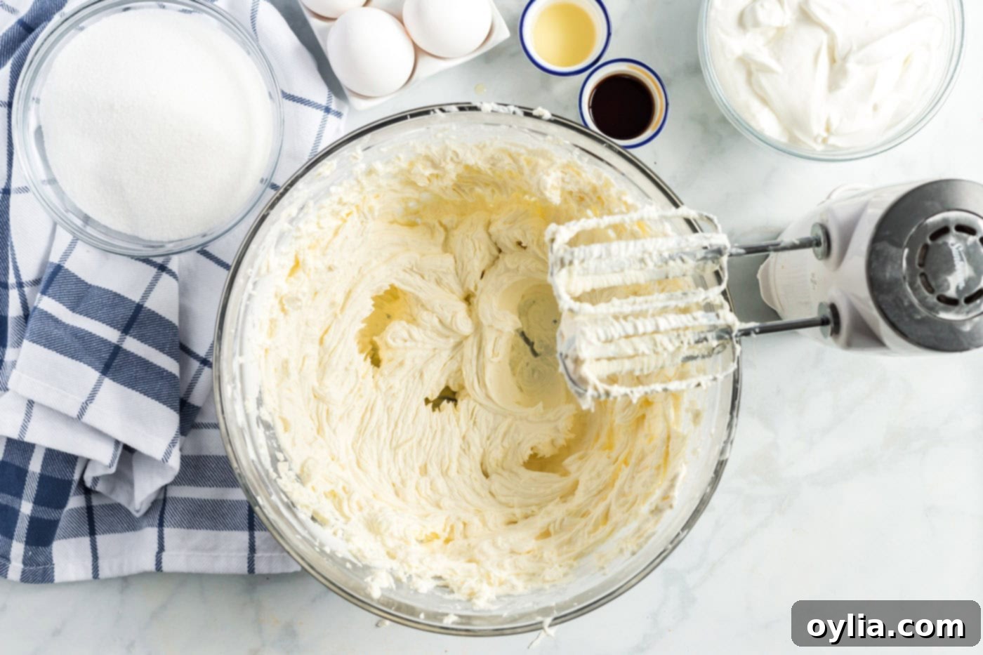 beaters with cream cheese mixture in a bowl, showing smooth consistency