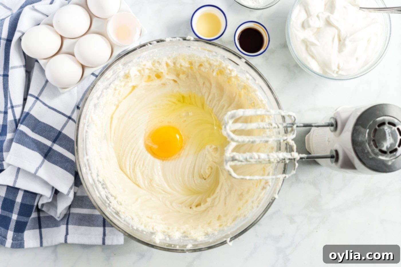 egg being mixed into the cream cheese batter