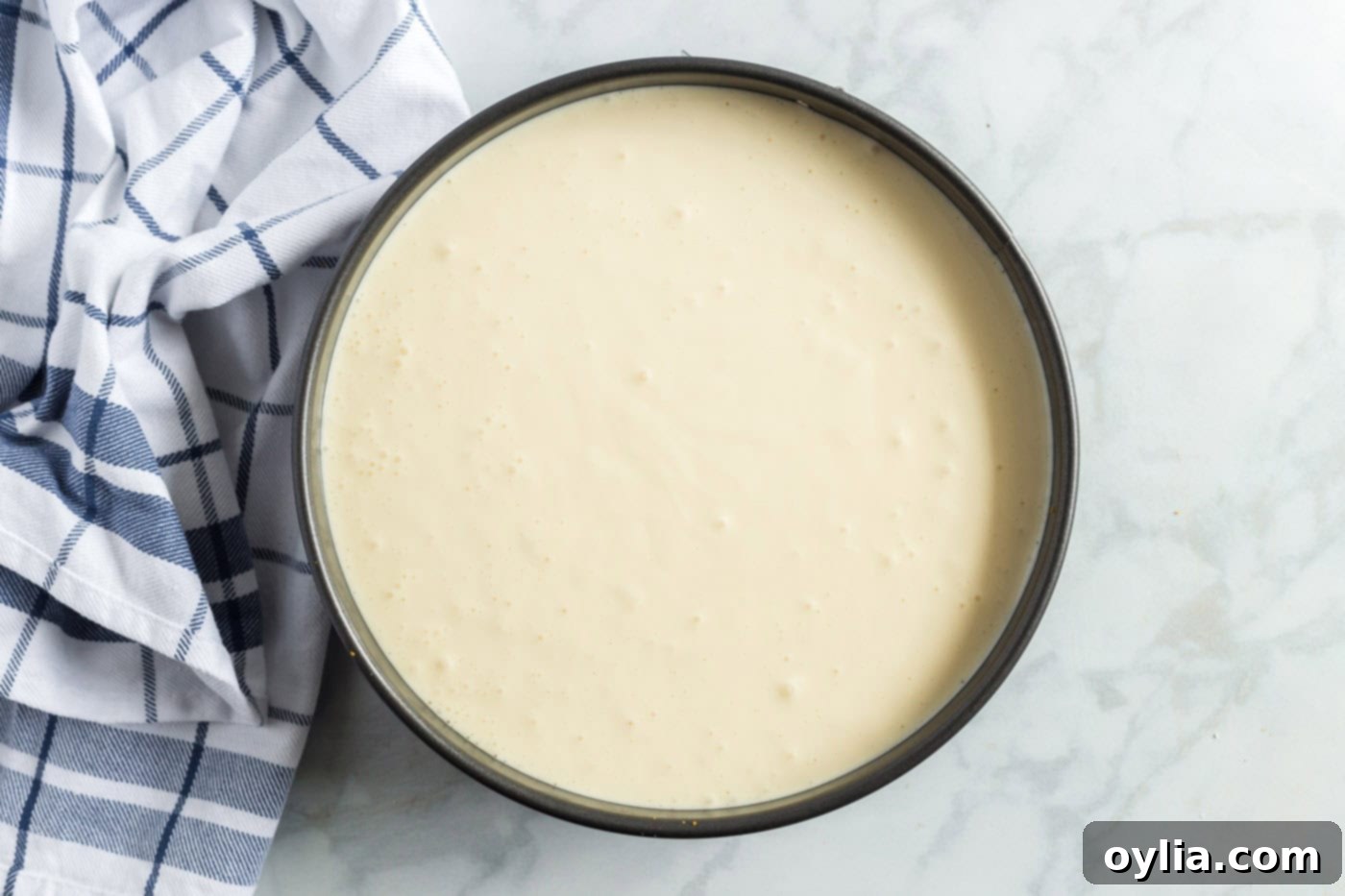 cheesecake mixture poured into a springform pan in a water bath