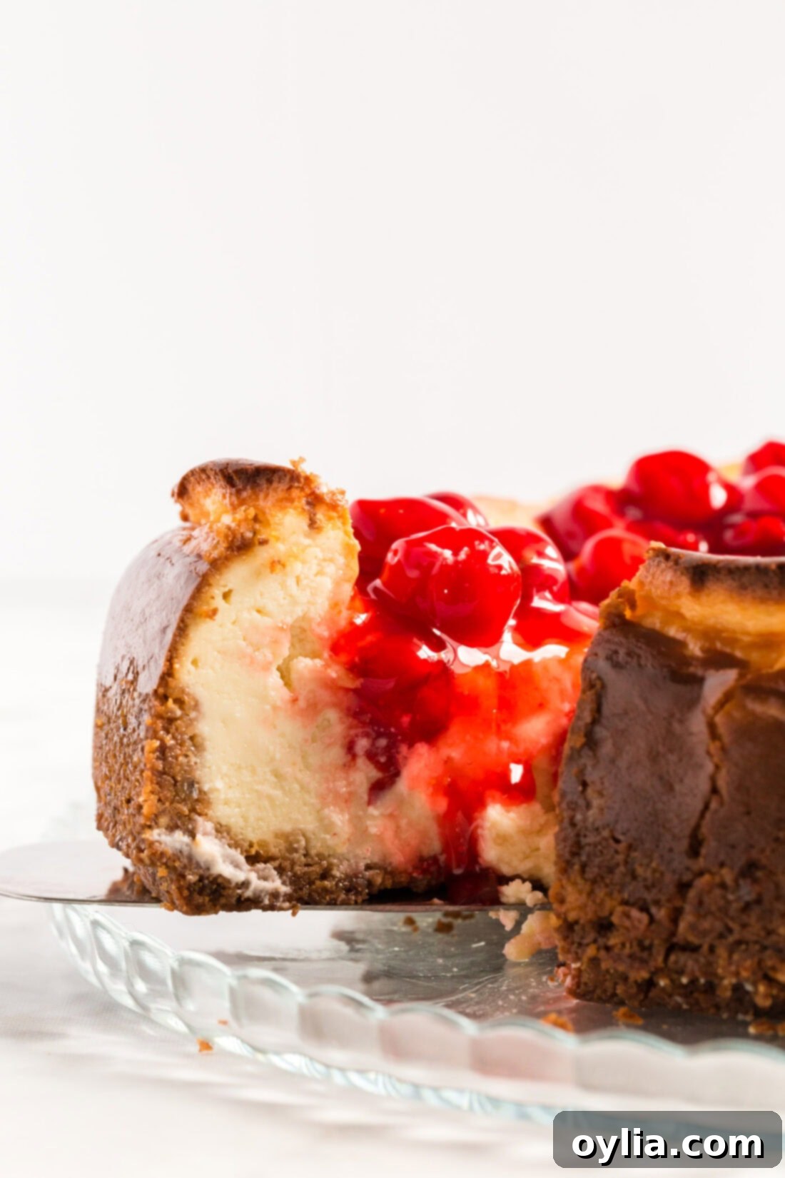 Slice of Cherry Cheesecake being removed from the springform pan, showing off its perfect shape.