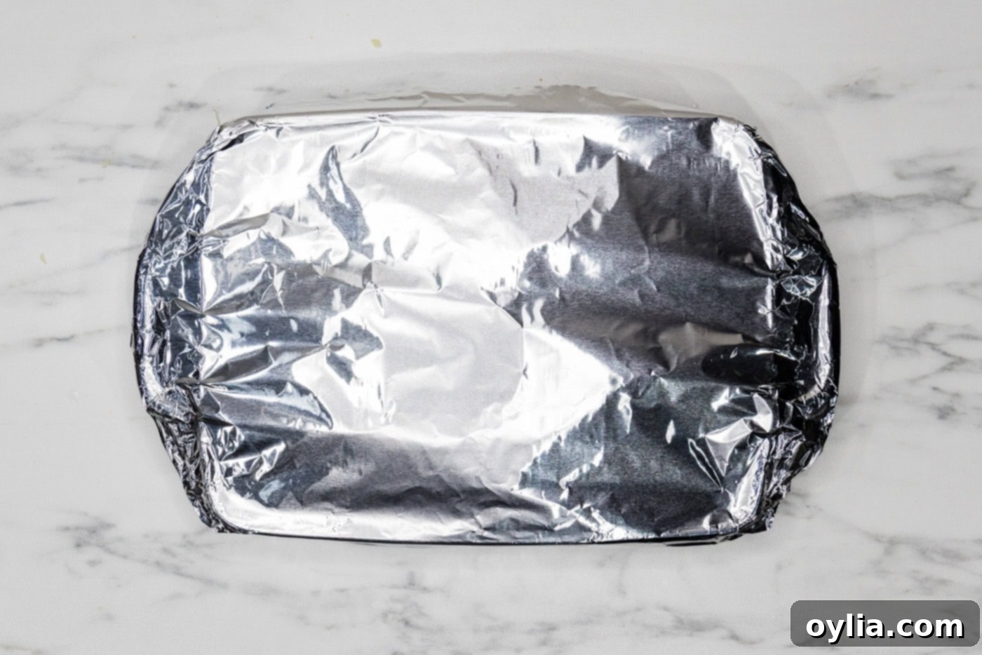 Overhead photo of lasagna baking dish covered with aluminum foil