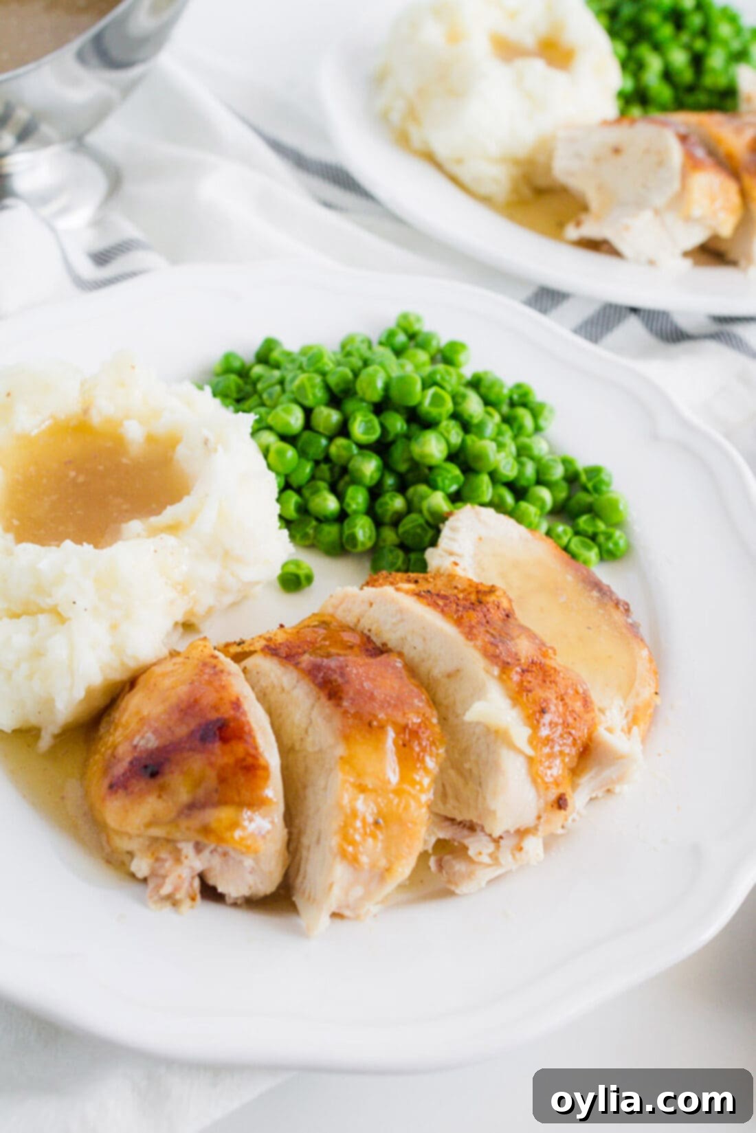 This crockpot chicken recipe is our family's favorite. We make good use of our slow cooker with this spice rubbed sticky chicken at least once a month. Crockpot Sticky Chicken on a plate with peas and mashed potatoes