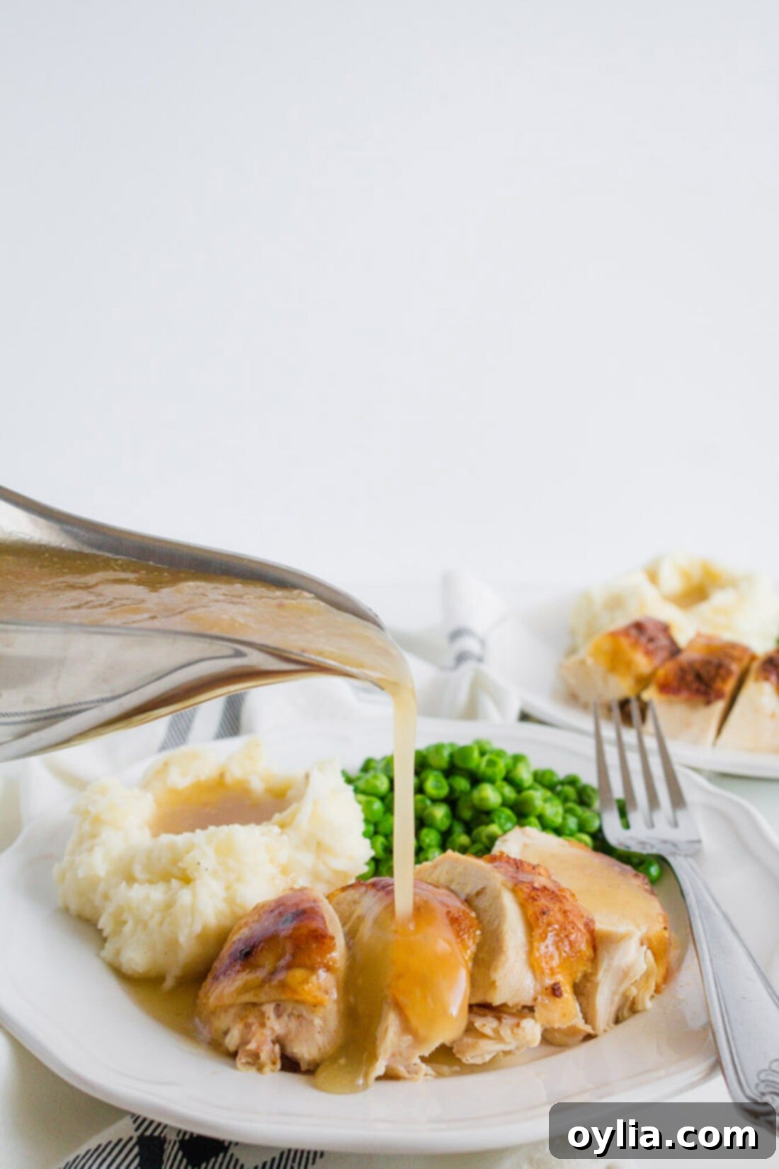 This crockpot chicken recipe is our family's favorite. We make good use of our slow cooker with this spice rubbed sticky chicken at least once a month. Gravy being drizzled on top of Crockpot Sticky Chicken