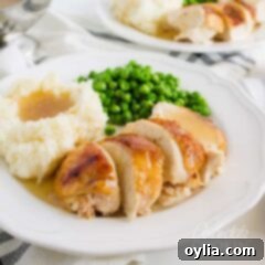 Sweet and Sticky Crockpot Chicken 2 sliced chicken with mashed potatoes and gravy on a plate