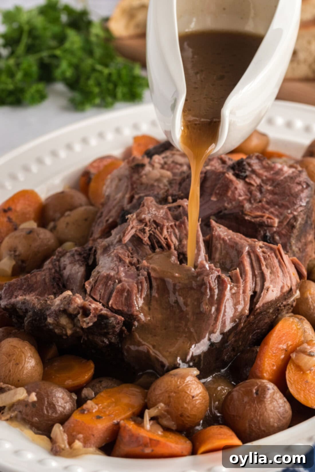 Gravy being poured over Crockpot Roast Beef on a platter