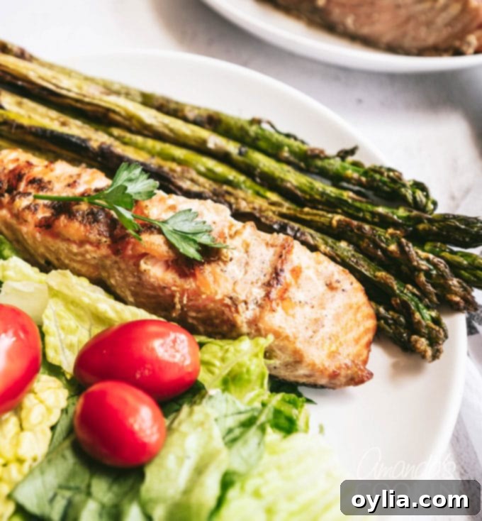 Succulent Grilled Salmon 3 grilled salmon steak on a plate with grilled asparagus and salad