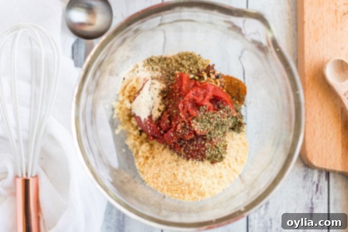 Mixing bowl with warm water, tomato paste, and other ingredients for pizza sauce.