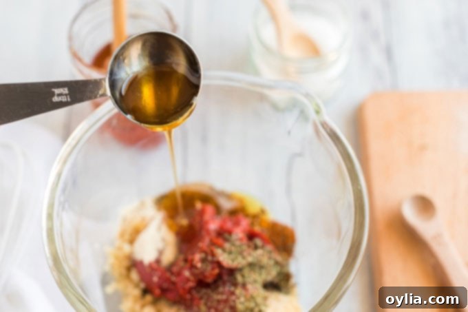 Adding a drizzle of sweet honey to the homemade pizza sauce mixture.