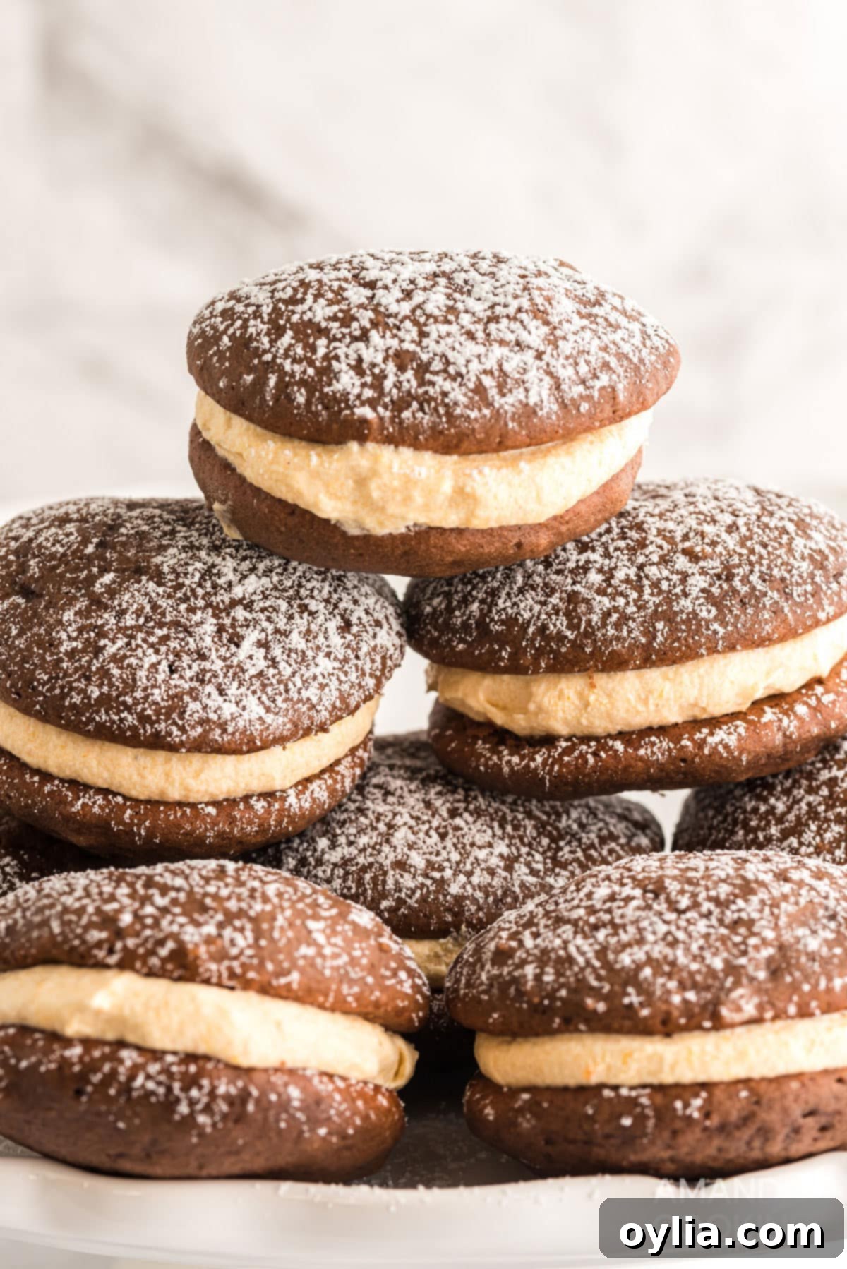 stack of pumpkin whoopie pies dusted with powdered sugar