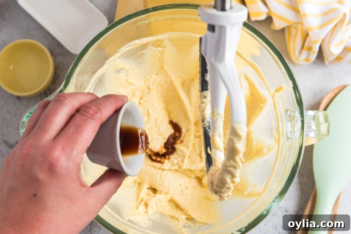Pouring vanilla extract into the butter, sugar, and egg mixture