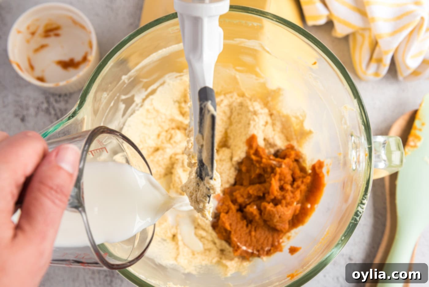Adding pumpkin puree and buttermilk to the butter mixture for muffins