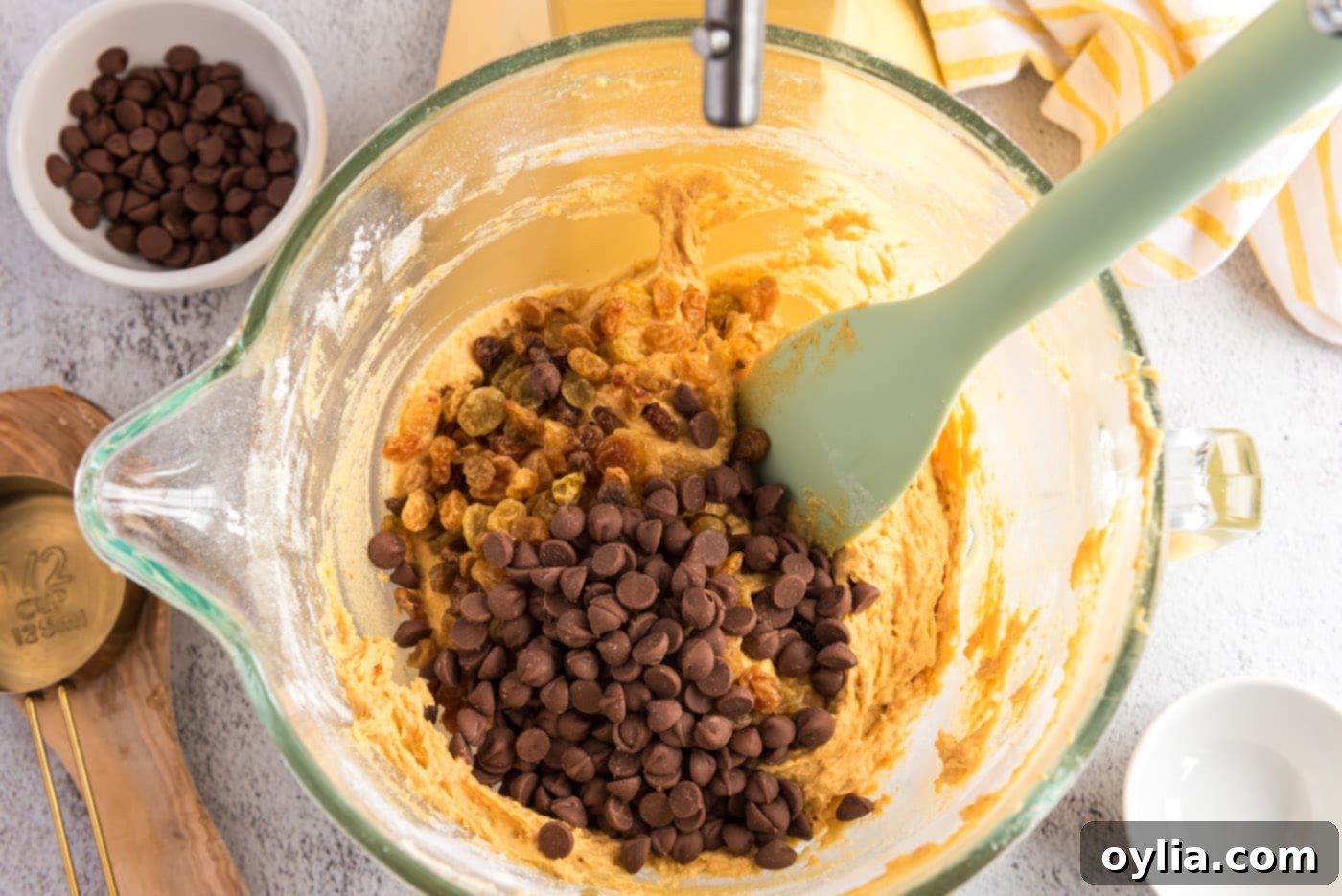 Adding chocolate chips and raisins to the pumpkin muffin batter
