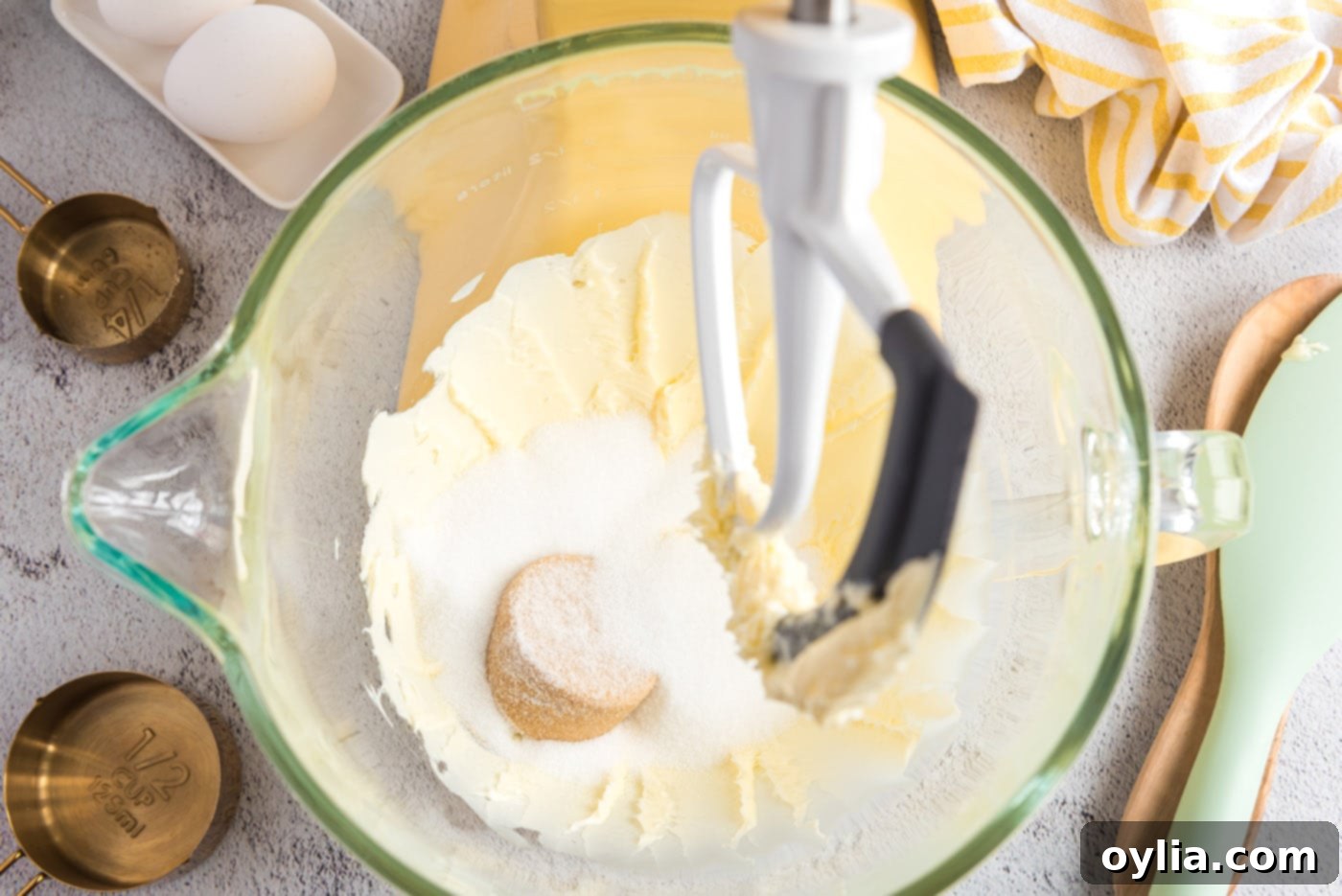 Adding granulated and brown sugars to the beaten butter mixture in a mixer