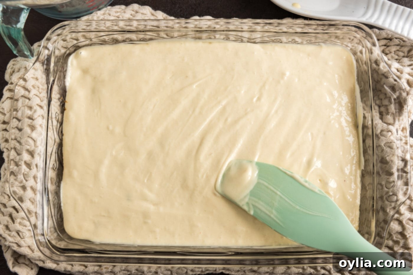 spreading cake batter over raspberries and brown sugar mixture