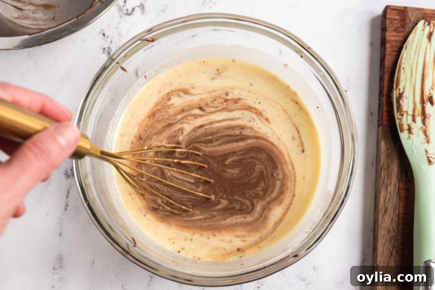 Whisking the melted chocolate mixture into the egg and cream mixture