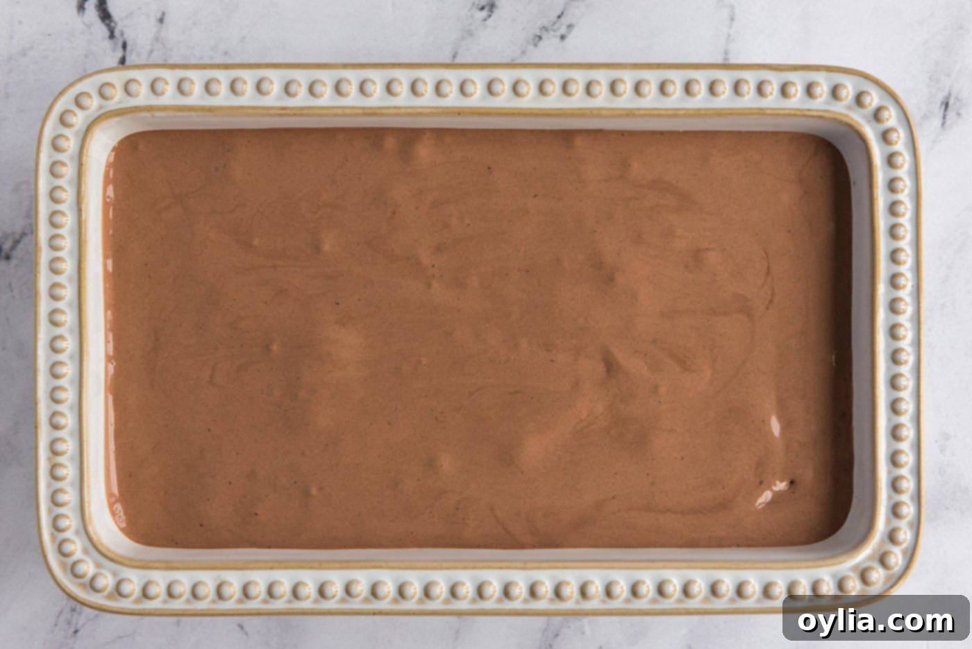 Homemade chocolate ice cream mixture poured into a loaf pan for final freezing