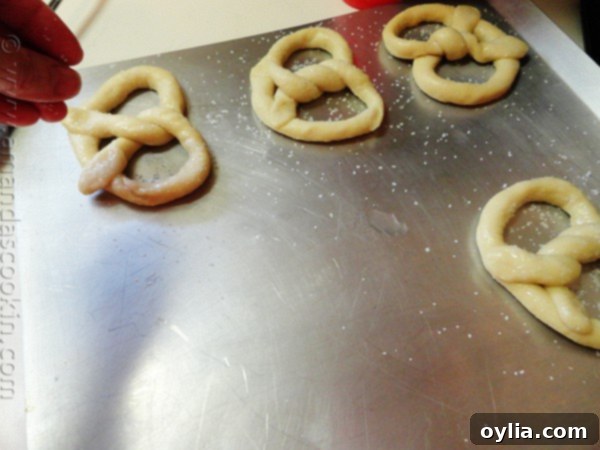 Bake Your Own German Pretzels 4 An overhead view of homemade German pretzel dough skillfully shaped into the classic pretzel knot, lying on a baking sheet.