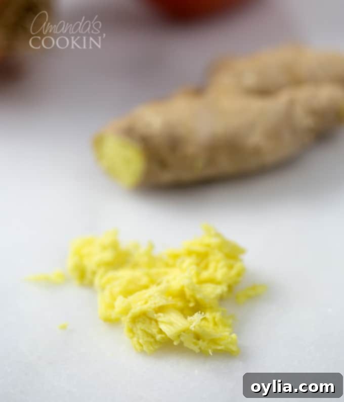 Chopped fresh ginger on a white cutting board.