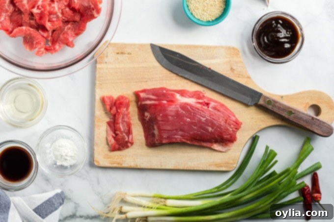 Raw flank steak on a cutting board, ready for slicing.
