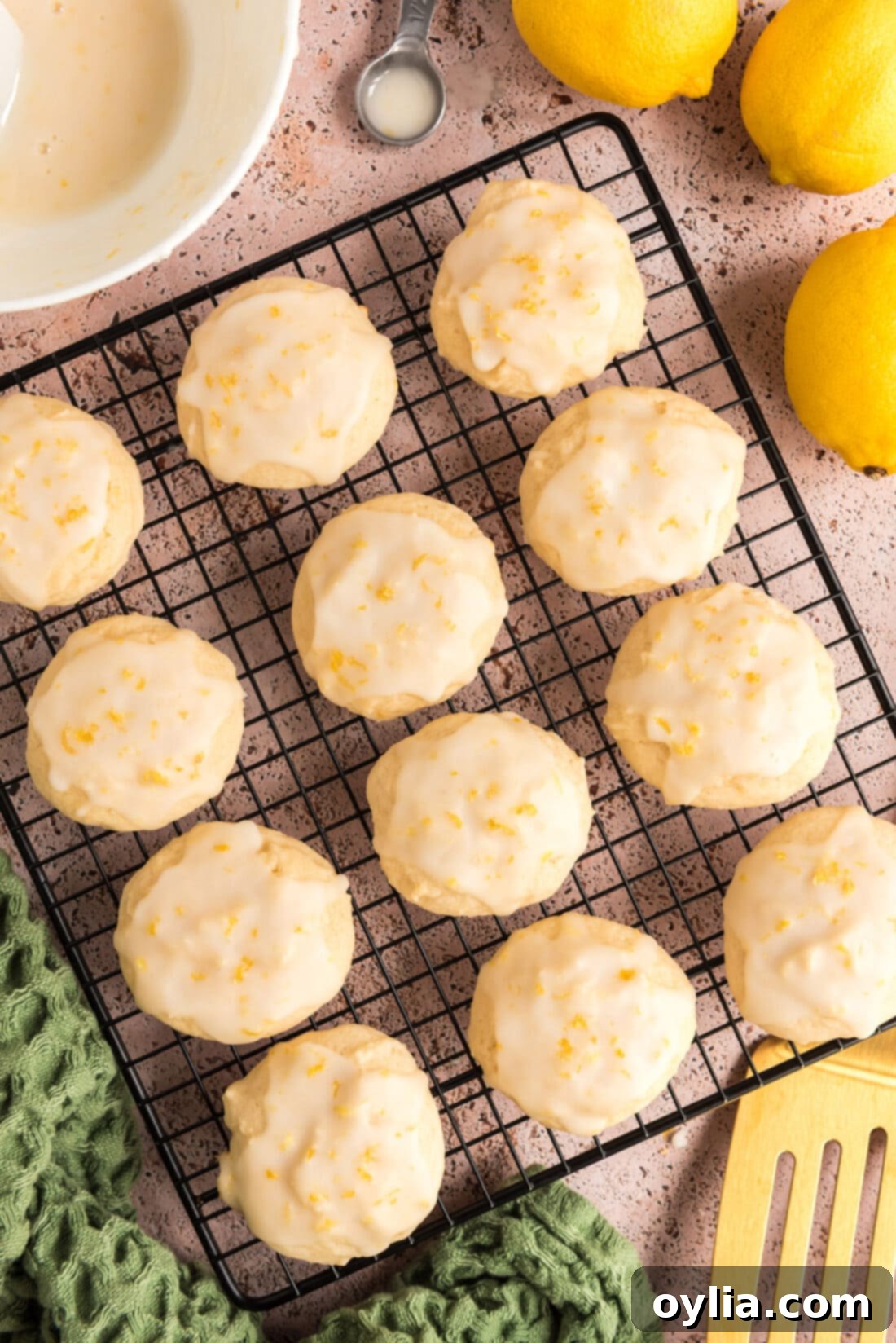 Freshly baked Lemon Drop Cookies cooling on a wire rack, showing their perfectly round shape and slightly crinkled tops.