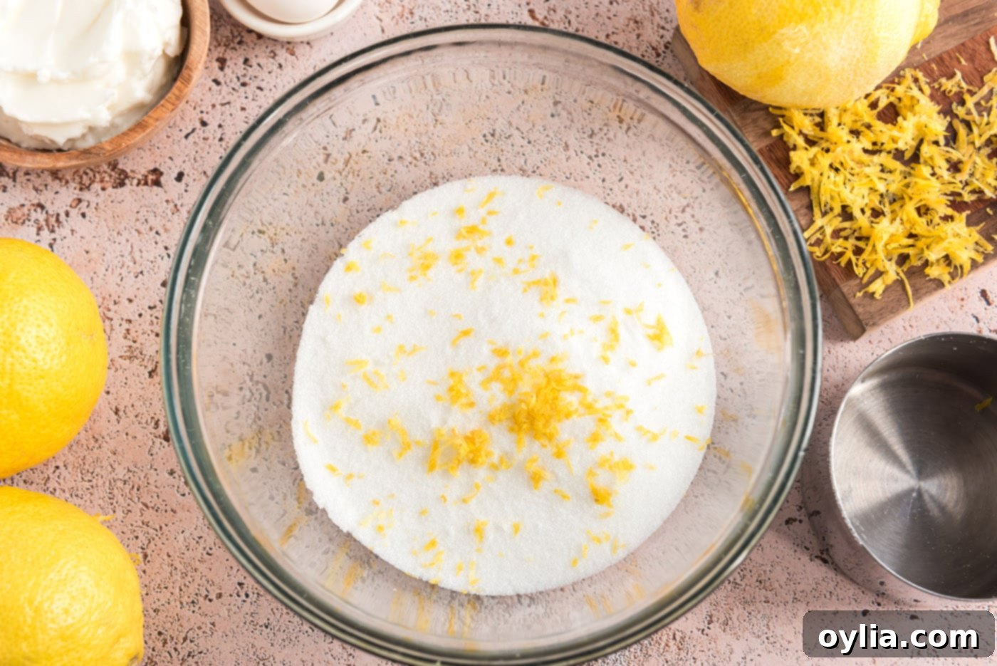 A bowl with granulated sugar and vibrant yellow lemon zest, prepped and ready for the flavor infusion step.