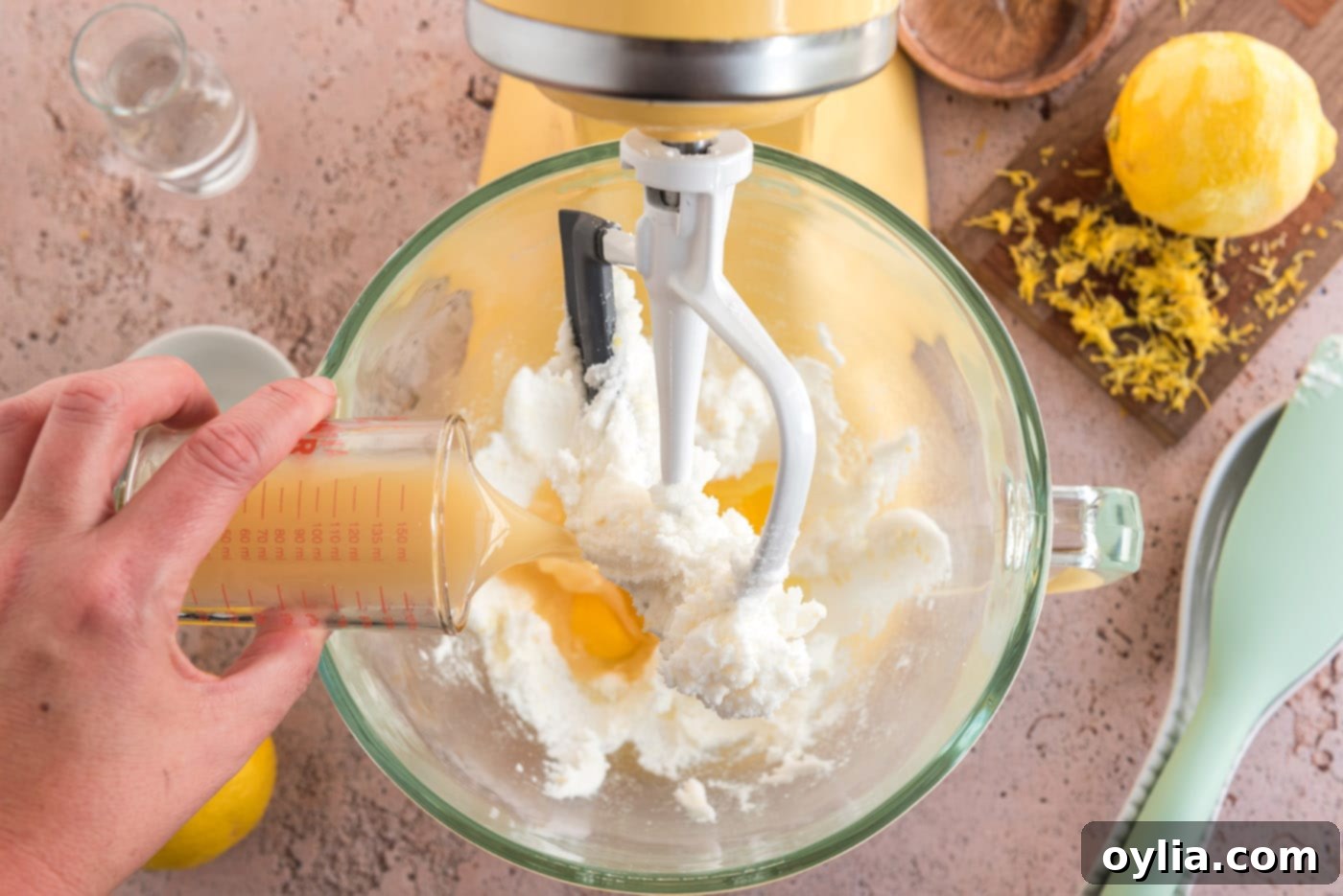 Freshly squeezed lemon juice being poured into the wet ingredients mixture for the cookie dough.