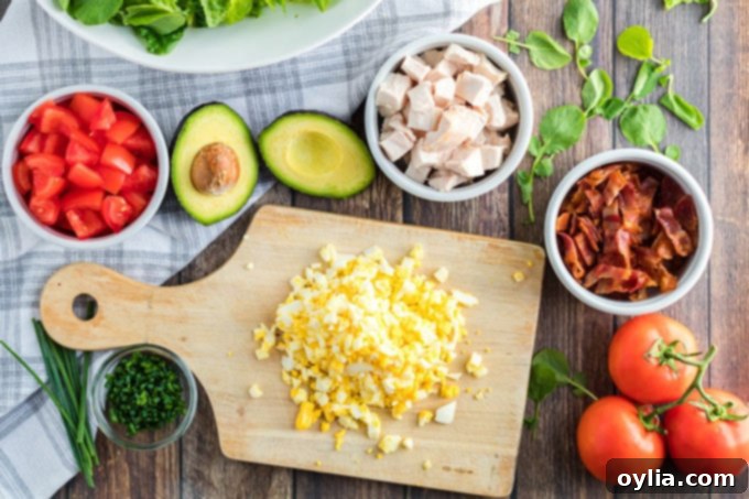 Various fresh ingredients for Cobb Salad laid out on a table