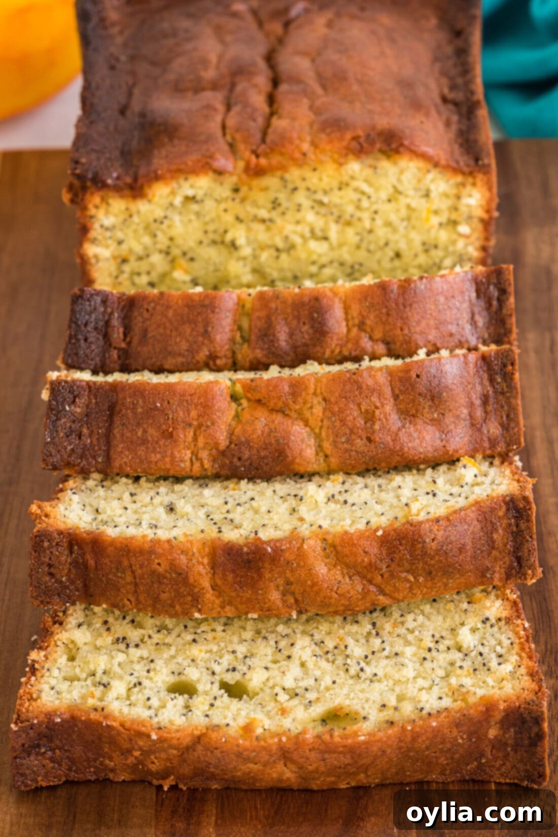 sliced Orange Poppy Seed Pound Cake, revealing moist interior and poppy seeds