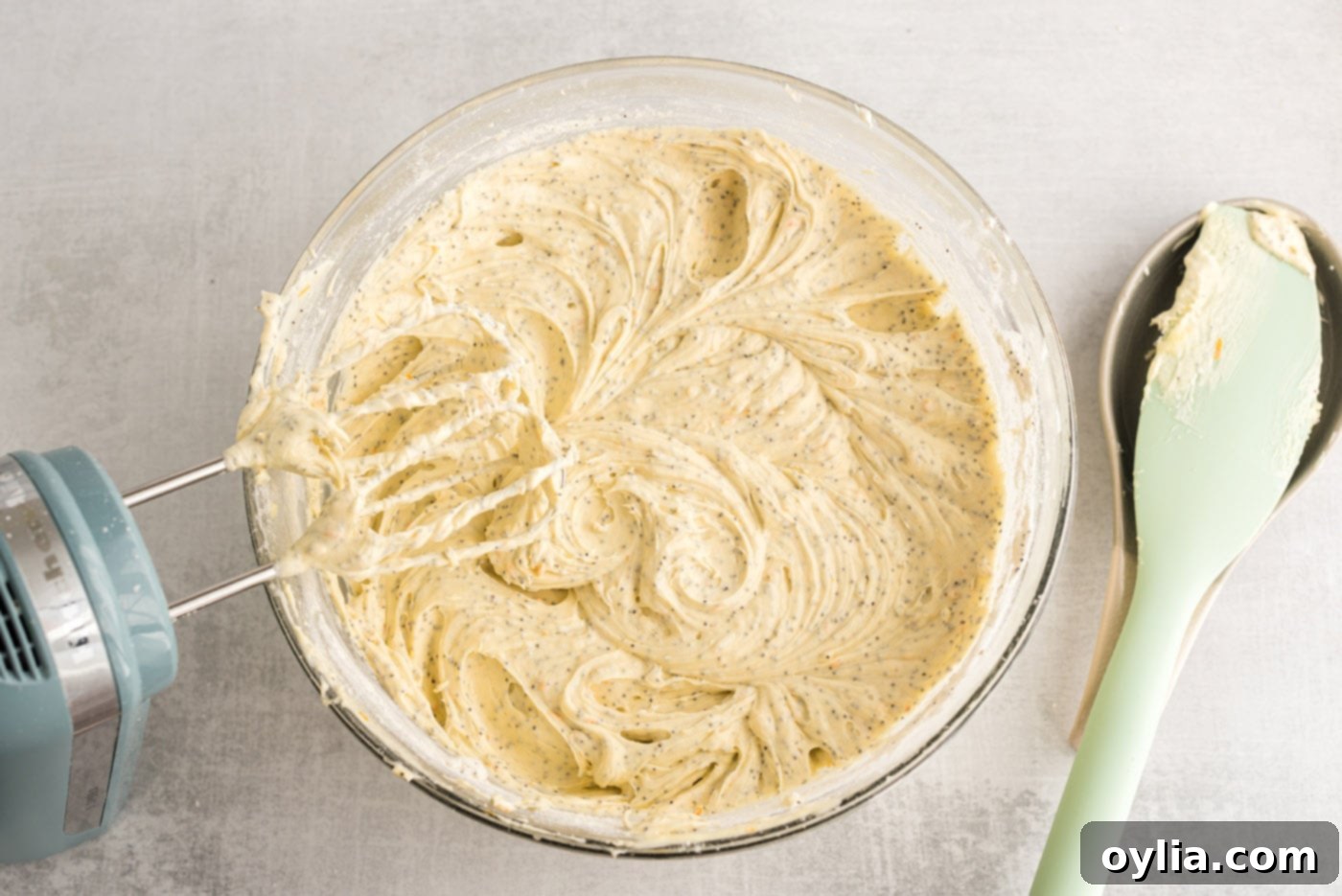 smooth orange poppy seed pound cake batter in a bowl, ready for baking