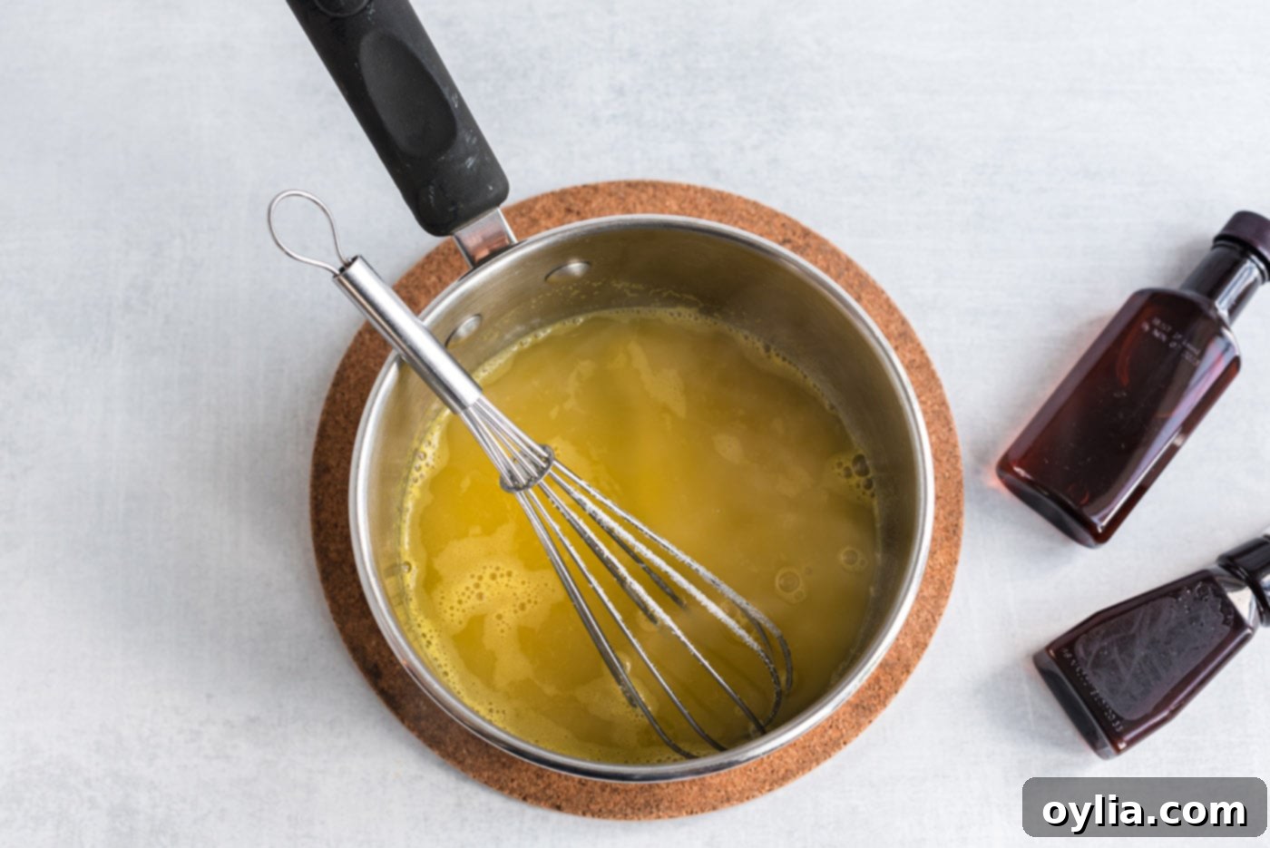 orange glaze mixture simmering in a saucepan, reducing to a thick syrup