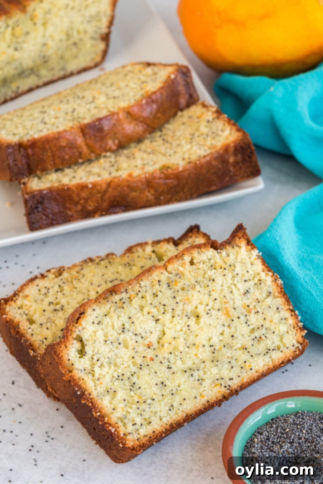 2 slices of Orange Poppy Seed Pound Cake on a plate, ready to be served