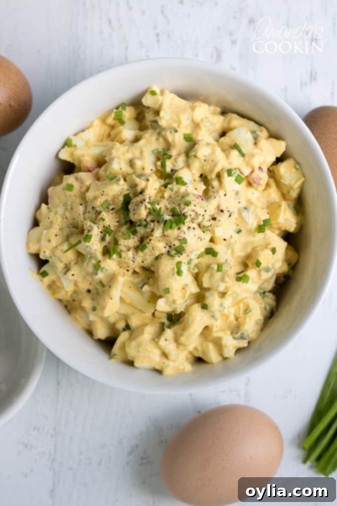 A close-up of Egg Salad with finely chopped chives and a hint of red bell pepper