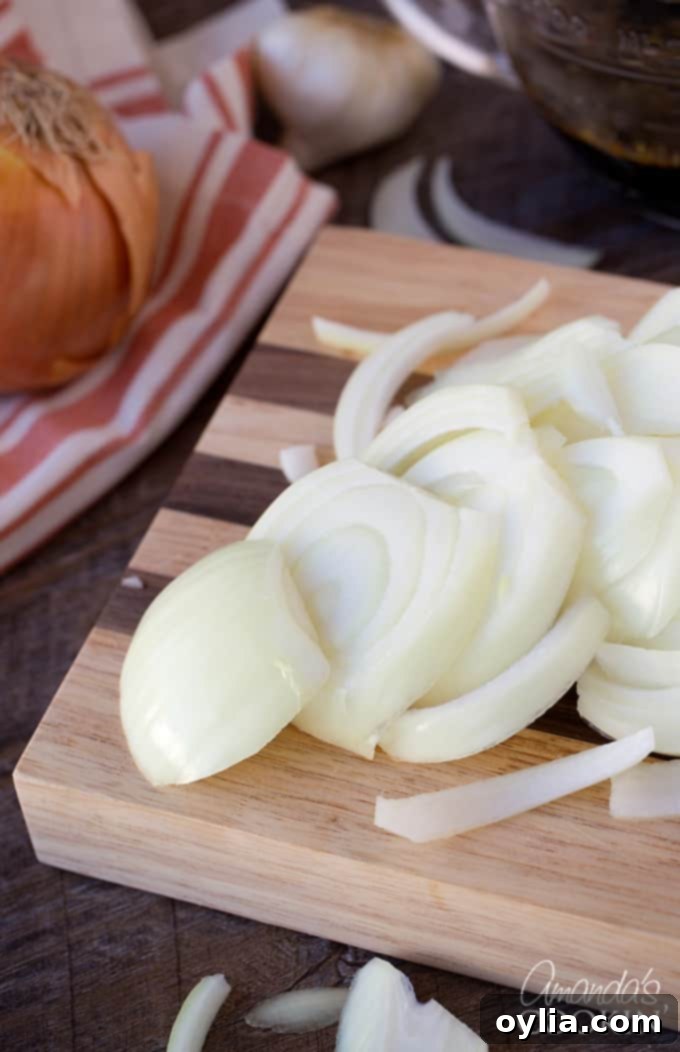 Slicing onions is the first step for this savory Amish Pot Roast recipe.